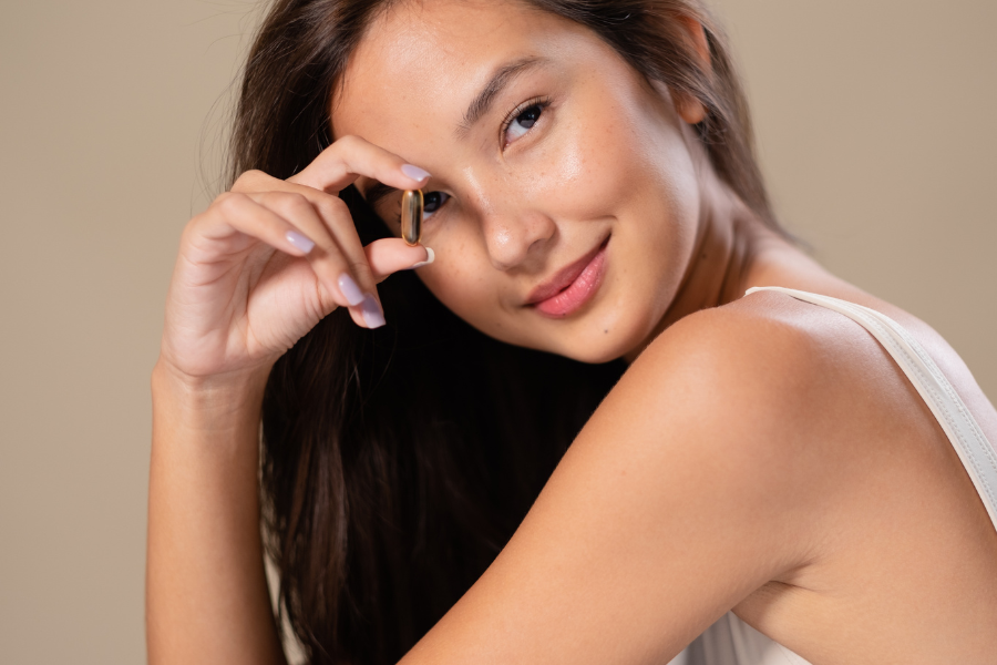 Woman holding a capsule skincare beside her face for targeted application