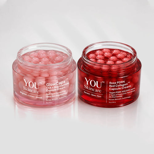 Two clear cosmetic jars filled with pink/red capsules on a white reflective background. The left jar is labeled YOU Skincare GlowCaps and the right jar is labeled YOU Skincare Rose DORN Red Collagen Capsule Cream.