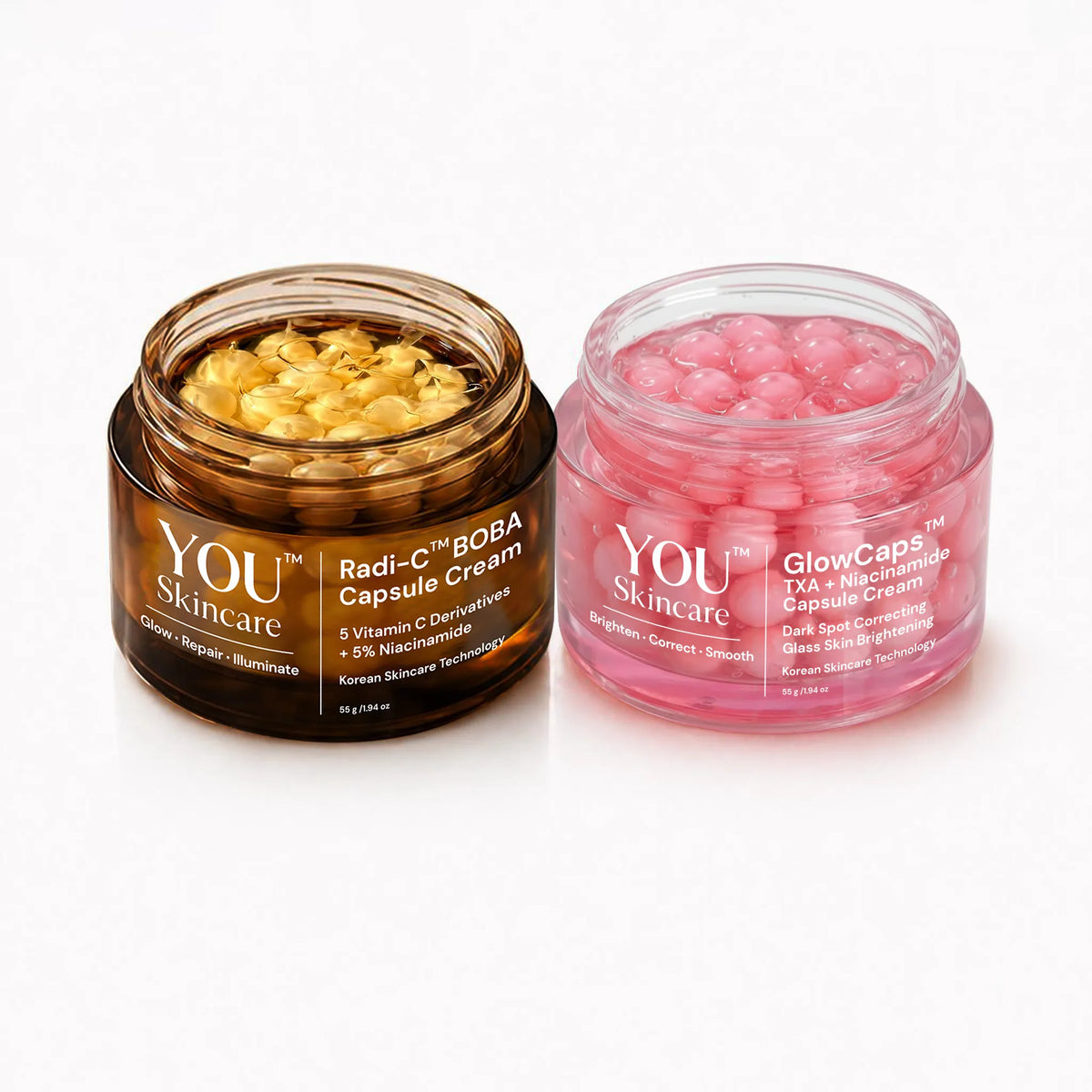 Two cosmetic jars from YOU Skincare on a white background: Radi-C BOBA Capsule Cream in a brown jar with golden capsules, and GlowCaps TCA + Niacinamide Capsule Cream in a pink jar with pink capsules.