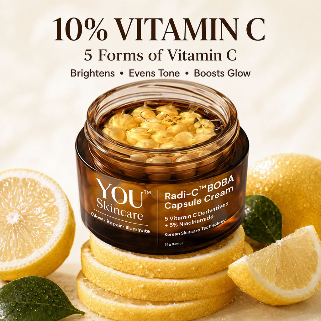 A jar of YOU Skincare Radi-C™ BOBA Capsule Cream with visible golden vitamin capsules inside, styled on stacked lemon slices with whole and sliced lemons and green leaves around it. Large text at the top reads '10% VITAMIN C' and '5 Forms of Vitamin C' with benefits listed below.