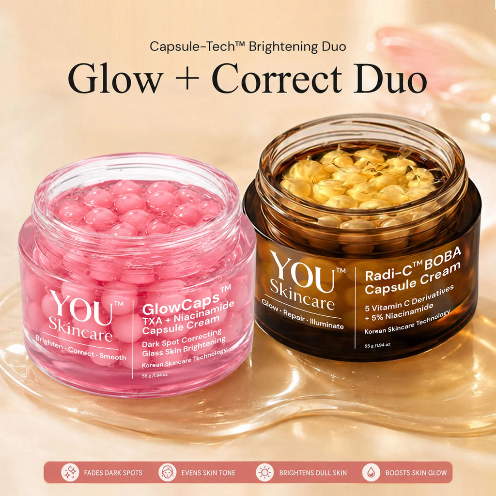 Two cosmetic jars from YOU Skincare displayed on a reflective gold tray against a warm beige background. On the left is a translucent pink jar labeled 'GlowCaps' containing pink capsules, and on the right is a dark amber jar labeled 'Radi-C BOBA Capsule Cream' containing golden-yellow capsules.