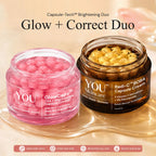 Two cosmetic jars from YOU Skincare displayed on a reflective gold tray against a warm beige background. On the left is a translucent pink jar labeled 'GlowCaps' containing pink capsules, and on the right is a dark amber jar labeled 'Radi-C BOBA Capsule Cream' containing golden-yellow capsules.
