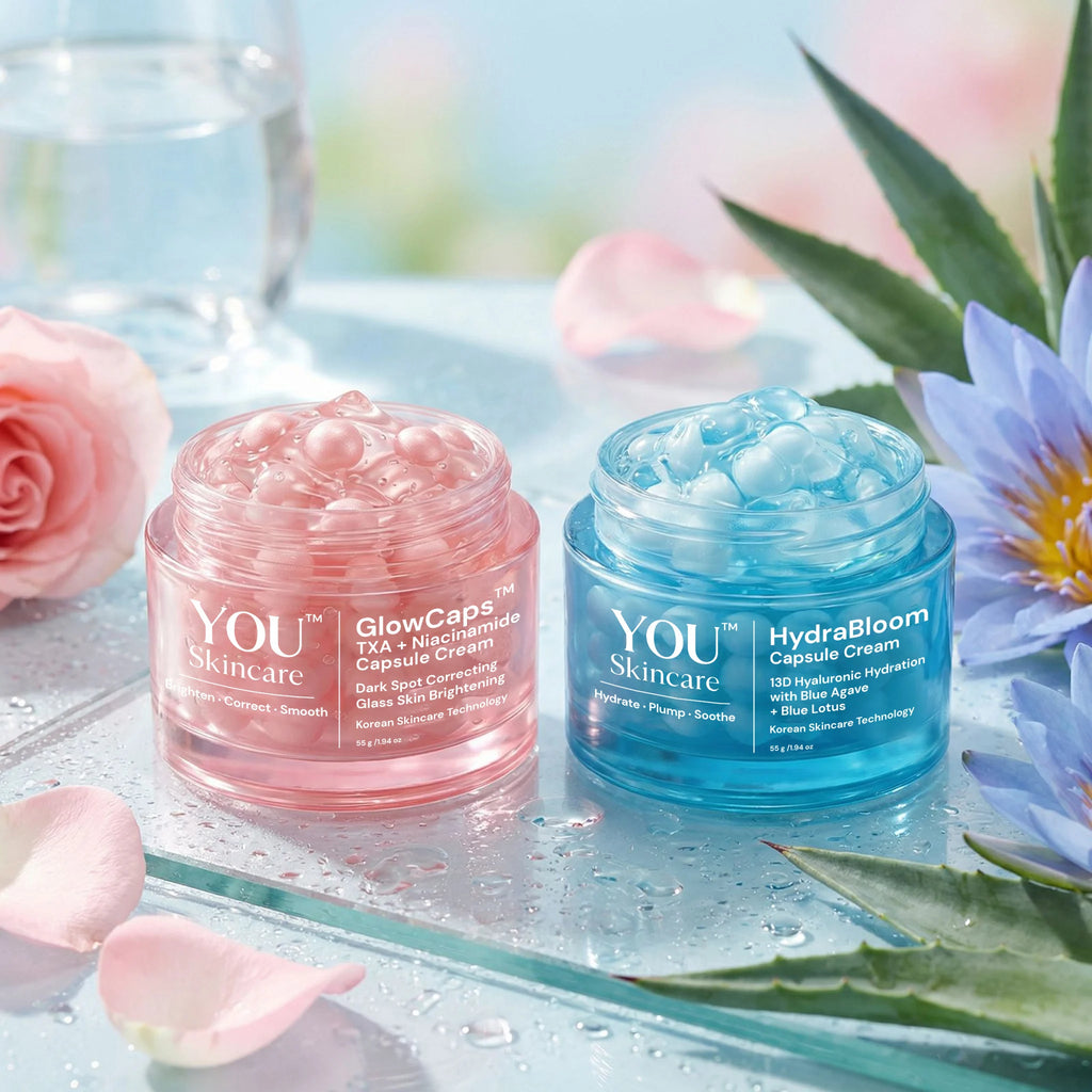 Two skincare cream jars, one pink and one blue, on a glass surface with flowers and water lilies in the background.