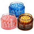 Three open cosmetic jars from YOU Skincare on a white background: a blue jar labeled HydraBloom Capsule Cream, a pink jar labeled GlowCaps encapsulating capsules, and a dark brown jar labeled Radi-C BOBA Capsule Cream showing yellow capsules inside.